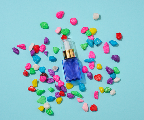 blue glass bottle with pipette on a blue background. Cosmetics SPA branding mockup, top view