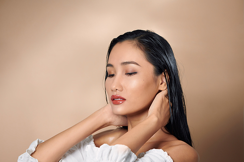 beautiful attractive elegant asian woman hand touch face model pose on studio photoshoot isolated white background
