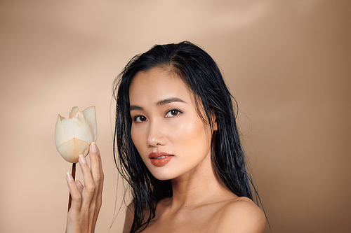 Beautiful young asian girl holding dried lotus buds in her hands.