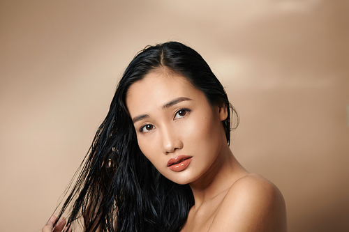 Beautiful sexy asian woman model posing on beige background