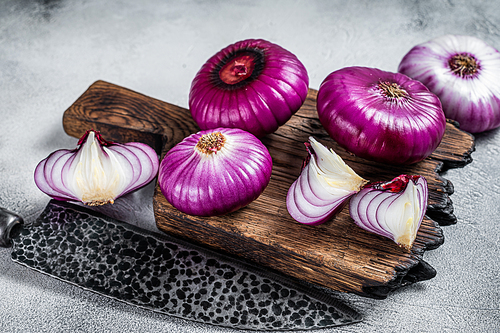 Sliced Flat red sweet onion on a cutting board. White background. Top View.