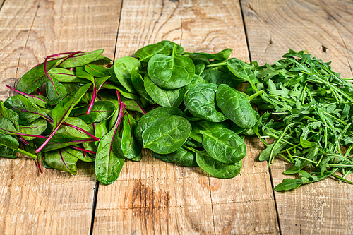 Mix Salad leafs, Arugula, Spinach and swiis Chard. Wooden background. Top view.