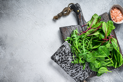 Fresh mixed greens, spinach, swiss chard and arugula. White background. Top view. Copy space.
