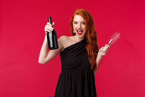 Celebration, holidays and women concept. Sassy and carefree young redhead woman having fun at awesome party, holding champagne and glass, enjoying night out with girlfriends.