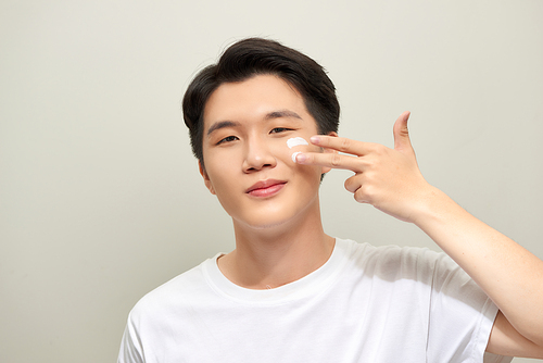 Handsome man applying - anti-aging concept
