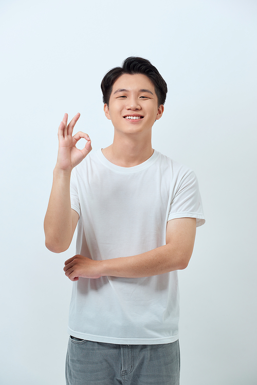 Everything is OK! Happy young man gesturing OK sign and smiling