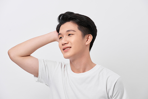 Young handsome man wearing white t-shirt over isolated background Smiling confident touching hair with hand up gesture