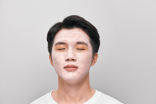 young man has mud clay mask on face