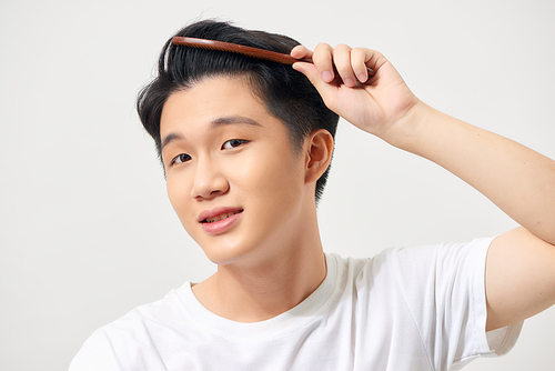 Handsome smiling young man doing modern hairstyle