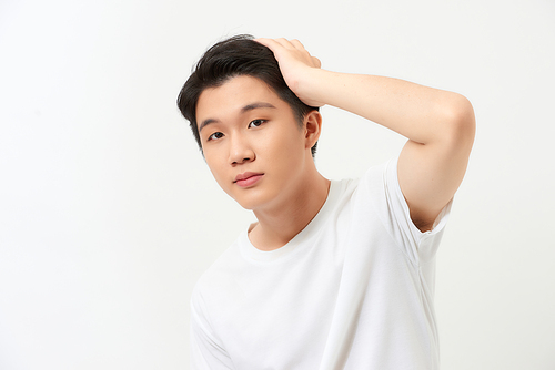 Young handsome man smiling confident touching hair with hand up gesture, posing attractive