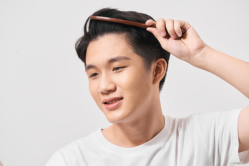 Handsome smiling young man doing modern hairstyle