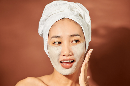 Young Asian woman enjoying of a facial mask treatment.