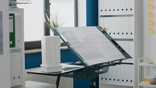 Close up of blueprints plan and building model on table in empty space used for construction and architectural project. Industrial sketch with urban real estate layout. Architecture design