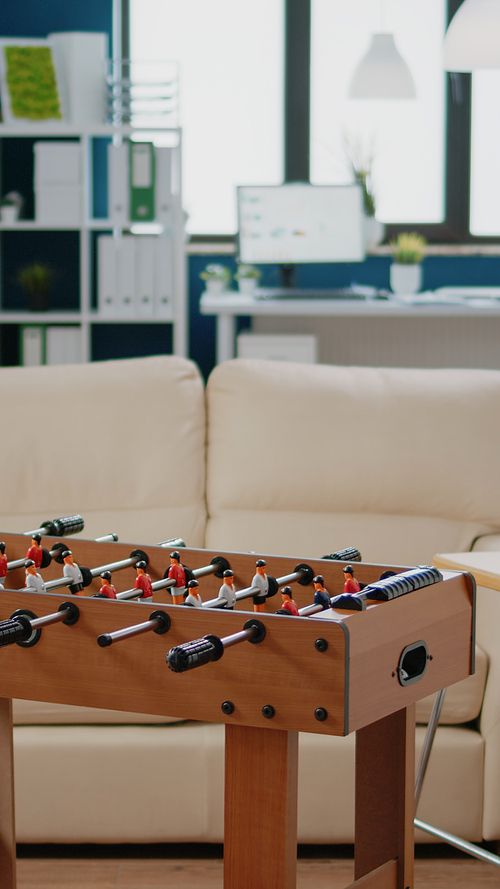 Nobody in workplace for businesspeople meeting after work for drinks and party celebration. Empty office with football game table, snacks and bottles with alcoholic beverage for fun