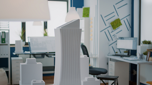 Close up of building model and urban structure on table in empty office. Construction maquette used for real estate design and property development. Nobody in architectural space