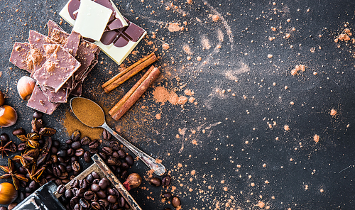 Chocolate, nuts, spices on a smooth black table