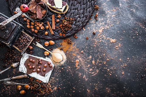 chocolate, cocoa and various  sweet spices on black table