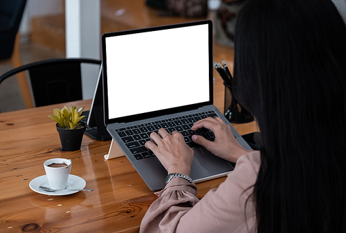 Young woman using laptop computer with blank white screen for business working at cafe.