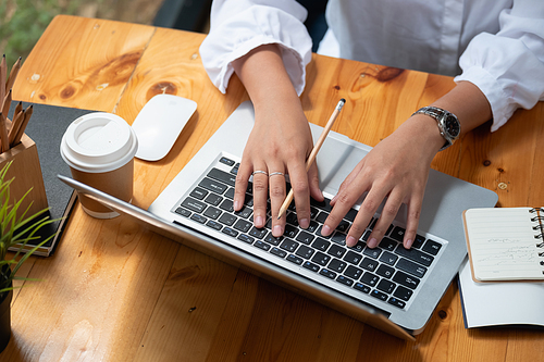 Woman using laptop computer at cafe, Hand of woman typing keyboard for online learning