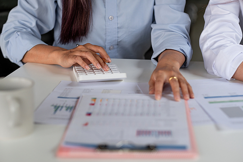 Close up accountant working on desk using calculator for calculate finance report in office