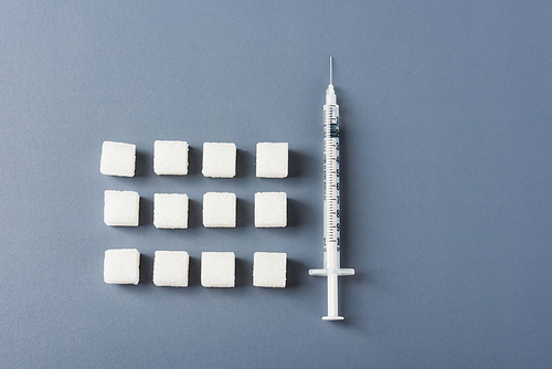 White sugar cube sweet food ingredient geometry pattern and syringe tube, studio shot isolated on a gray background, Minimal health high blood risk of diabetes and calorie intake concept