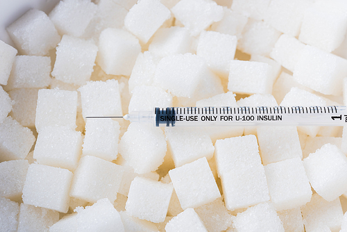 Sugar cube texture background sweet food ingredient and syringe, studio shot health high blood risk of diabetes and calorie intake concept