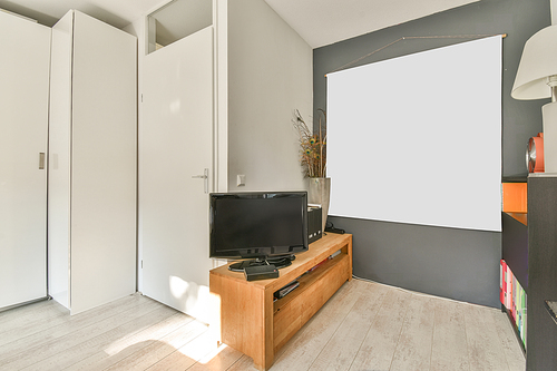 Corner of a bright cozy room with a TV on the chest of drawers