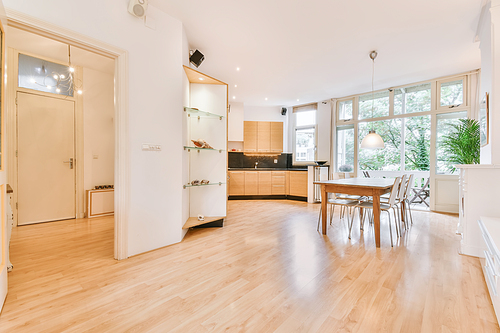 Home interior design of modern loft apartment with open kitchen in minimalist style and spacious dining zone with table and chairs