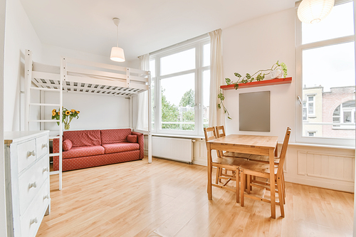 Cozy room with red sofa and wooden table and chairs