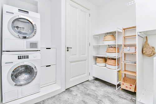 Bright laundry room with washing machine and shelves on the wall