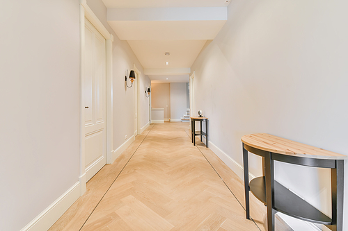 Long stunning hallway with wood flooring and white walls