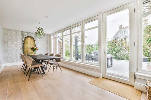 Large dining room with large table and chairs and a full side wall window