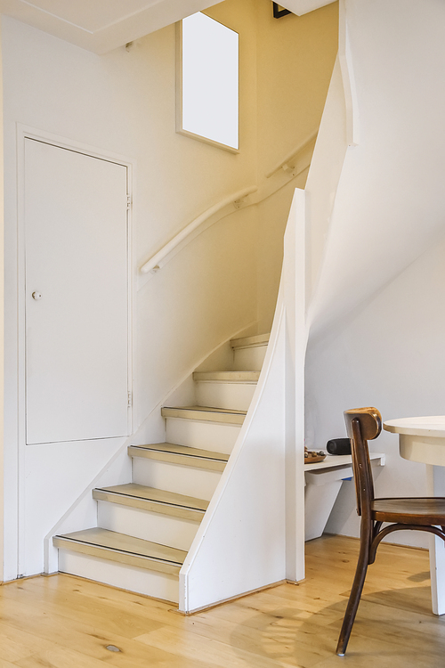 Cozy spiral white staircase with a painting on the wall