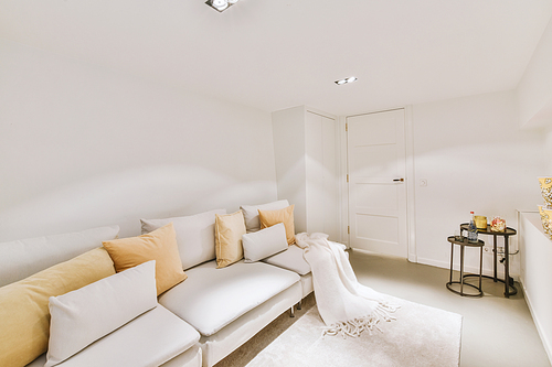 A guest area with a large white sofa in front of a large TV in a modern house