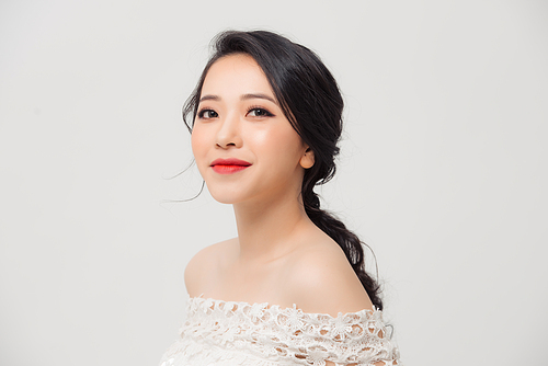 Close up portrait of beautiful young Asian woman isolated over white background. Beauty concept.