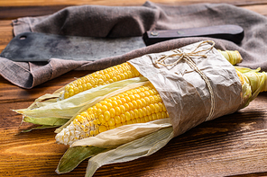 Fresh harvested corn cob on farmer market, local vegetables. Wooden background. Top view.