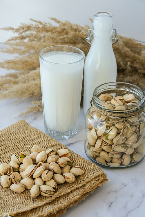 Pistachio lactose free milk for dietary nutrition. Alternative food and vegetarianism. Glass of healthy pistachio milk stands on concrete background. Diet milk, vegetarian food. Gluten free. Nut non-dairy milk