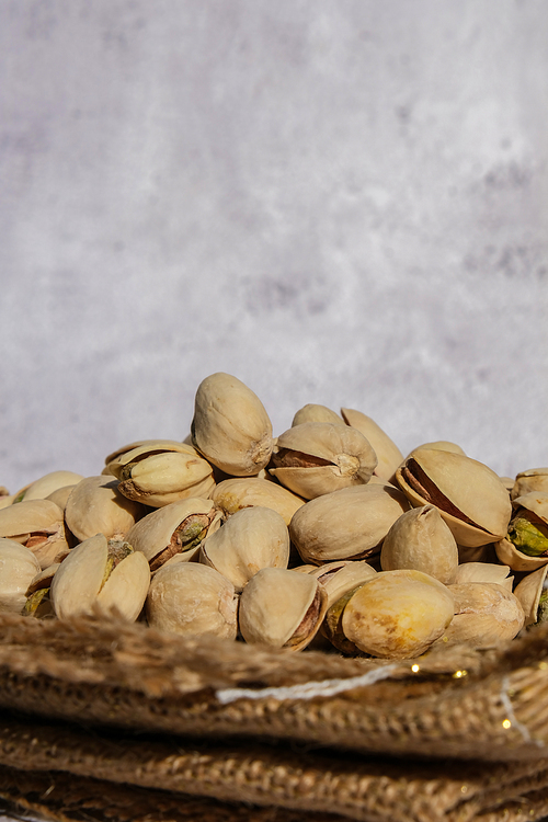 Pistachios in burlap sack on concrete table. Organic pistachios. Vegan Healthy food high protein. Dietary nutrition. Concept of nuts omega vitamin