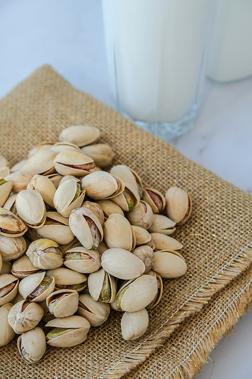 Pistachio lactose free milk for dietary nutrition. Alternative food and vegetarianism. Glass of healthy pistachio milk stands on concrete background. Diet milk, vegetarian food. Gluten free. Nut non-dairy milk