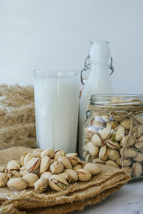 Pistachio lactose free milk for dietary nutrition. Alternative food and vegetarianism. Glass of healthy pistachio milk stands on concrete background. Diet milk, vegetarian food. Gluten free. Nut non-dairy milk