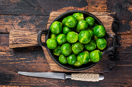 Boiled Brussels green sprouts cabbage in a pan. Dark wooden background. Top view.