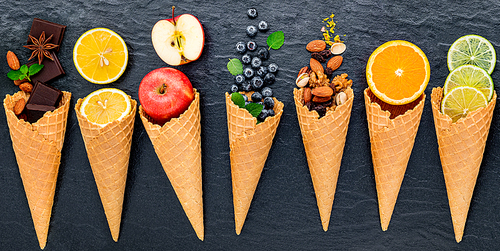 Various of ingredient for ice cream flavor in cones  set up on dark stone background .