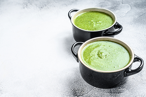 Homemade broccoli and spinach cream soup in bowl. White background. Top view. Copy space.