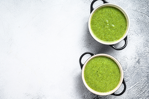 Homemade broccoli and spinach cream soup in bowl. White background. Top view. Copy space.