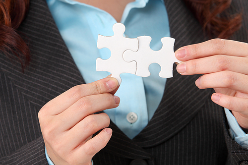 close up of woman holding puzzle pieces