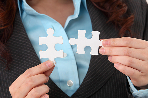 close up of woman holding puzzle pieces