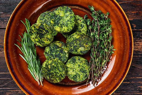 Fried vegetarian broccoli vegetable burgers patty on a rustic plate. Dark wooden background. Top view.