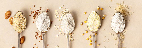 metal spoons of various gluten free flour almond flour, oatmeal flour, buckwheat flour, ., corn flour