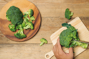 Top view of Chef hand cutting broccoli for cooking