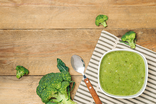Tasty broccoli soup on a wooden background